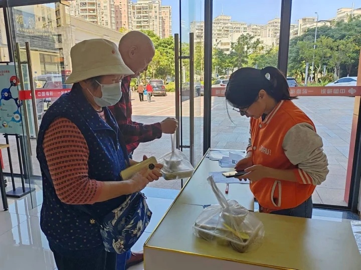 老人到家门口的老年助餐点领取午餐。（来源：惠州日报社）