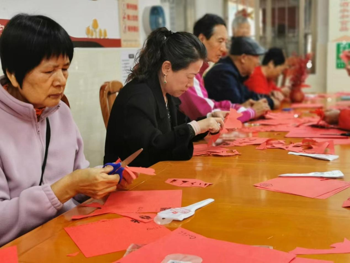 高新区唐家社区通过举办剪纸窗花活动，让长者感受传统文化的魅力。（摄影：吴凯琳）